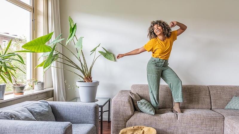woman dancing on the sofa at home